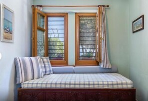 A room with a wooden bed, a window with curtains, and a wall-mounted picture. - Stolios Skopelos - Thalia Superior Panoramic Seaview (Skopelos)