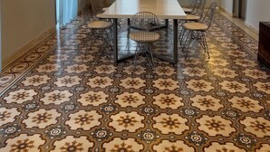 A dining area with a patterned floor, a white table, and metal chairs. - Tinion Urban Hotel (Tinos)
