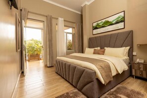 A bedroom with a large bed, a bedside table, a nightstand, and a window with curtains. - Inganzo boutique hotel (Kigali)