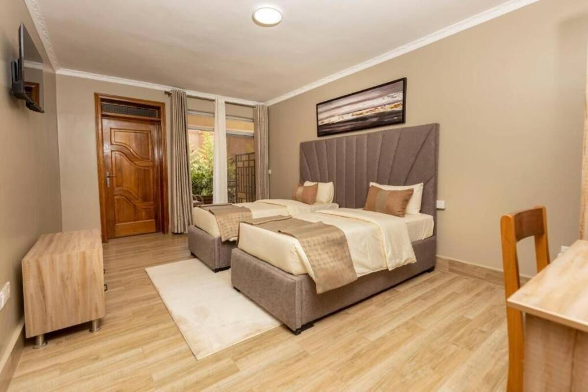 Un dormitorio con una cama grande, una mesita de noche, una silla y vistas al exterior a través de una puerta corredera.