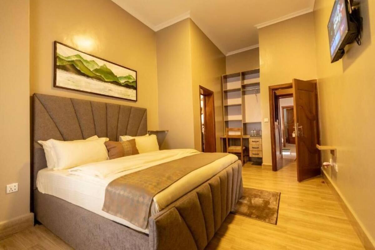 Un dormitorio con cama, un cuadro, televisor y armario.