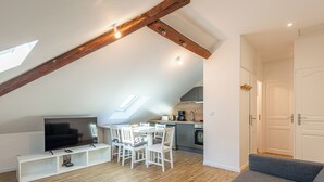 A modern loft apartment with a dining area, kitchen, and living space. - Le  Joseph - Appartement au calme (Annecy)