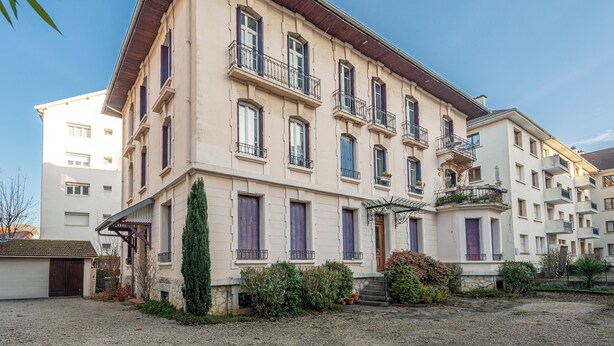 A multi-story building with a symmetrical facade, multiple balconies, and a central entrance with steps. - Le  Joseph - Appartement au calme (Annecy)
