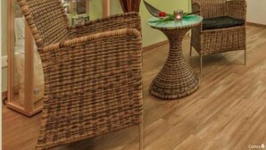 A spa room with wicker furniture, a glass cabinet, and a wall sign reading "LASS DIE Seele BAUME". - Kaiserhof Feldberg Wheelchair Accessible Room (Feldberger Seenlandschaft)