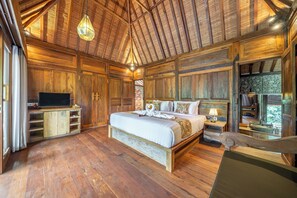 Ein geräumiges Schlafzimmer mit einem großen Bett, Holzwänden und einem Kamin aus Stein.