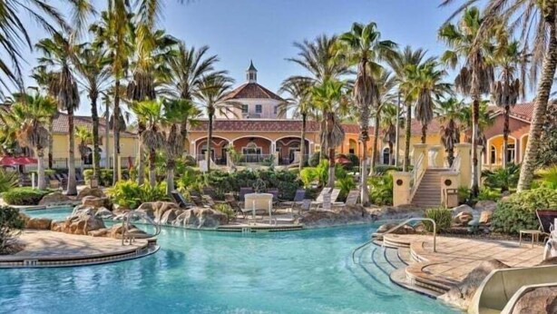 A resort with a central pool, palm trees, and a building with a red roof. - Rp216bd 3b Regal Palms Townhome 3 Bedroom Townhouse (Davenport)