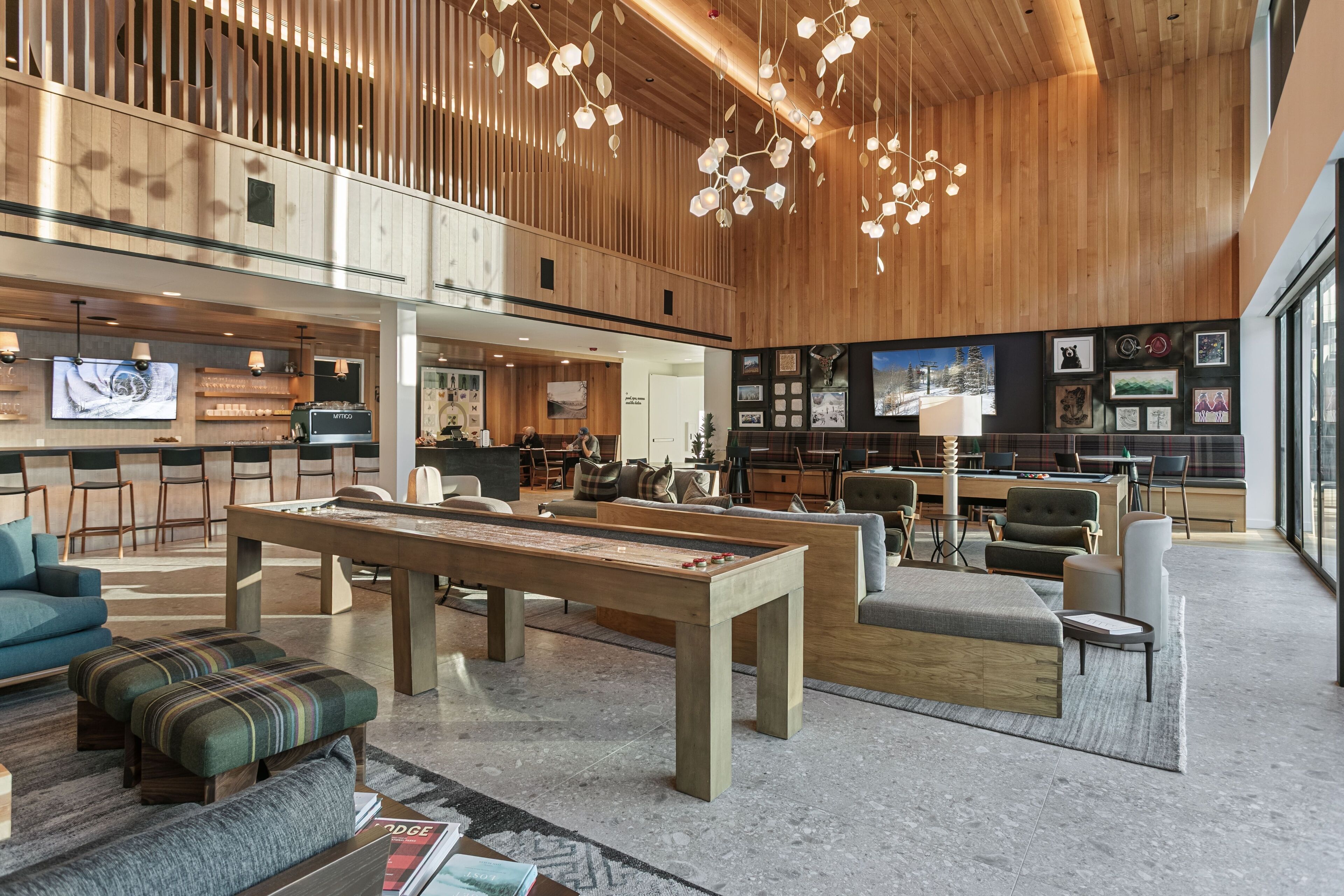 Un hall d’entrée spacieux avec une table de billard, des sièges confortables et un plafond en bois.