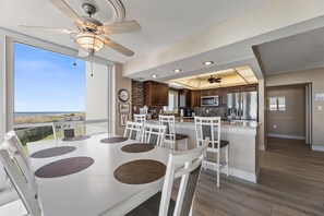 A modern kitchen with a central island, wooden cabinets, and stainless steel appliances. - Shoreline Towers 1021 3 Bedroom Condo (Destin)