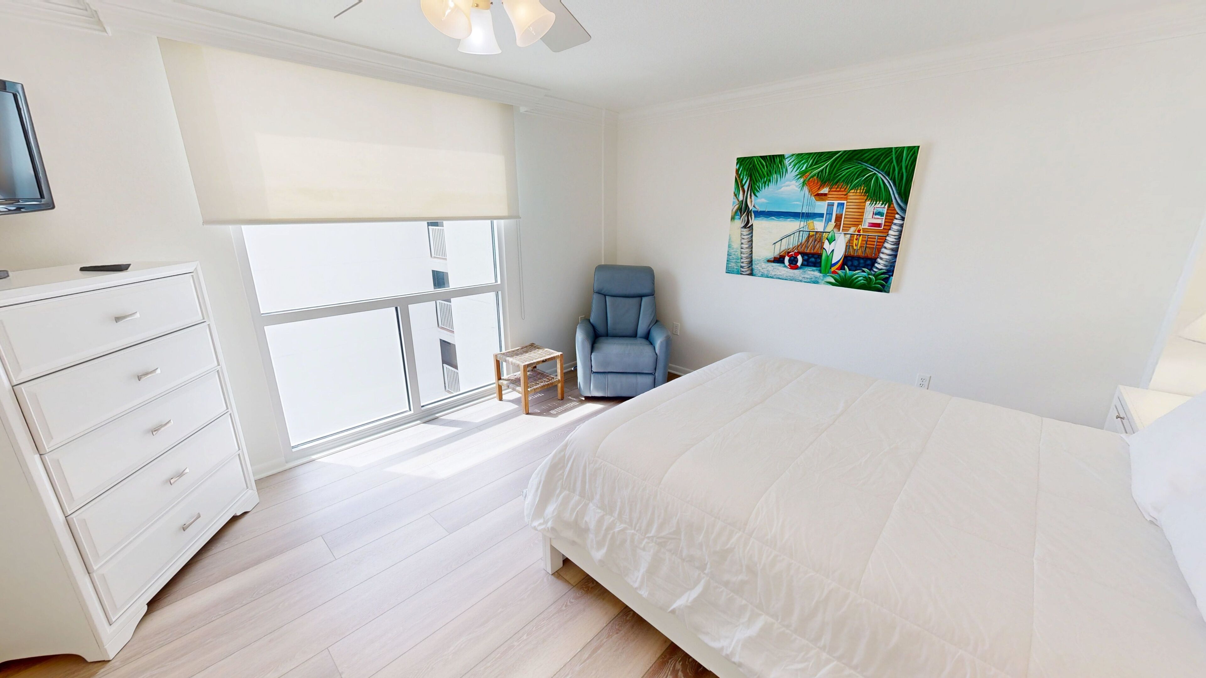 A bedroom with a bed, a chair, a dresser, a window, and a painting.