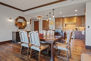 A dining room with a wooden table and six upholstered chairs, a large mirror, and a clock on the wall. - Ski In/ski Out Mid-mountain Getaway 2 Bedroom Condo (Park City)