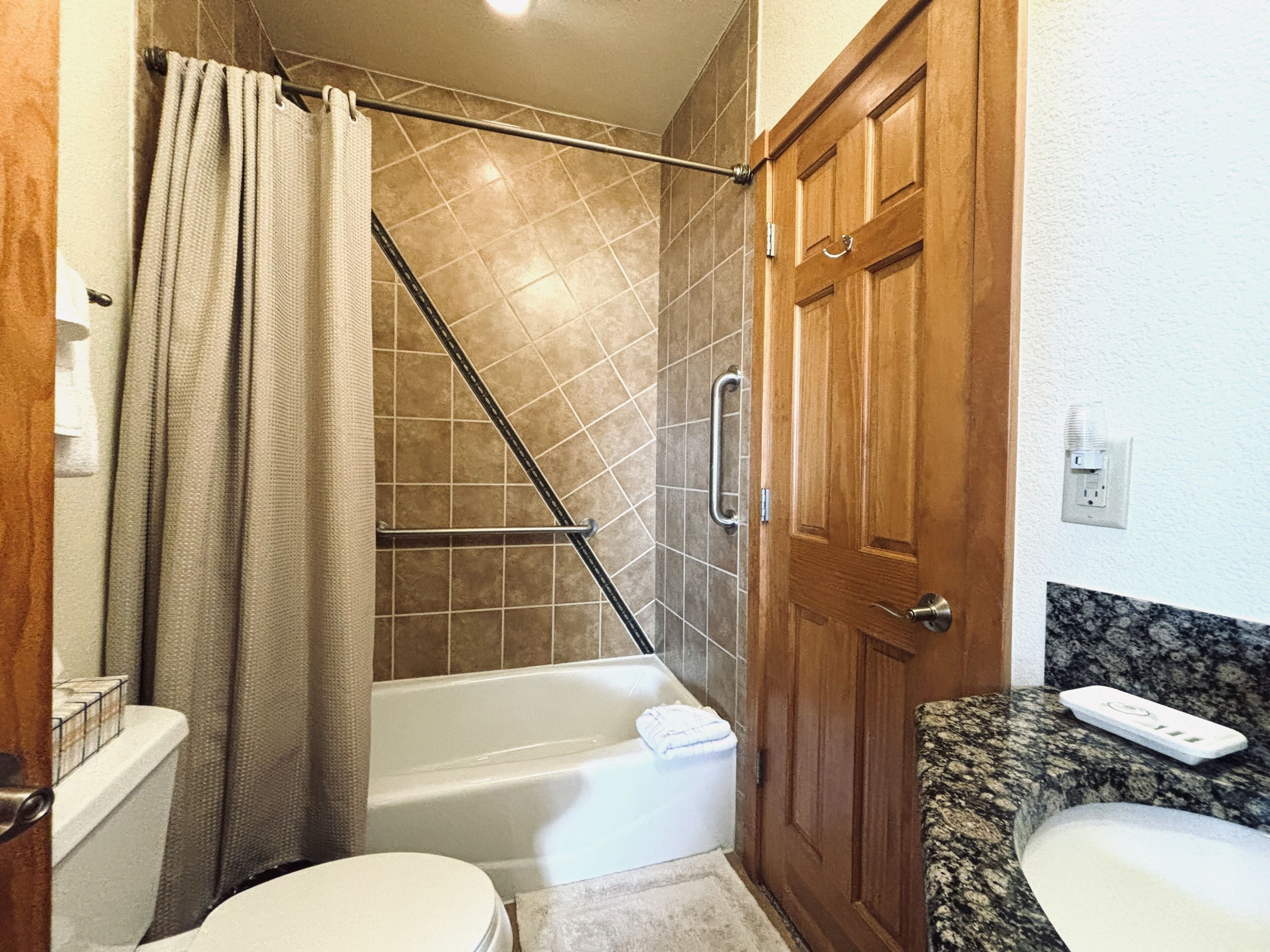Ein Badezimmer mit Dusche, Toilette und Waschbecken.