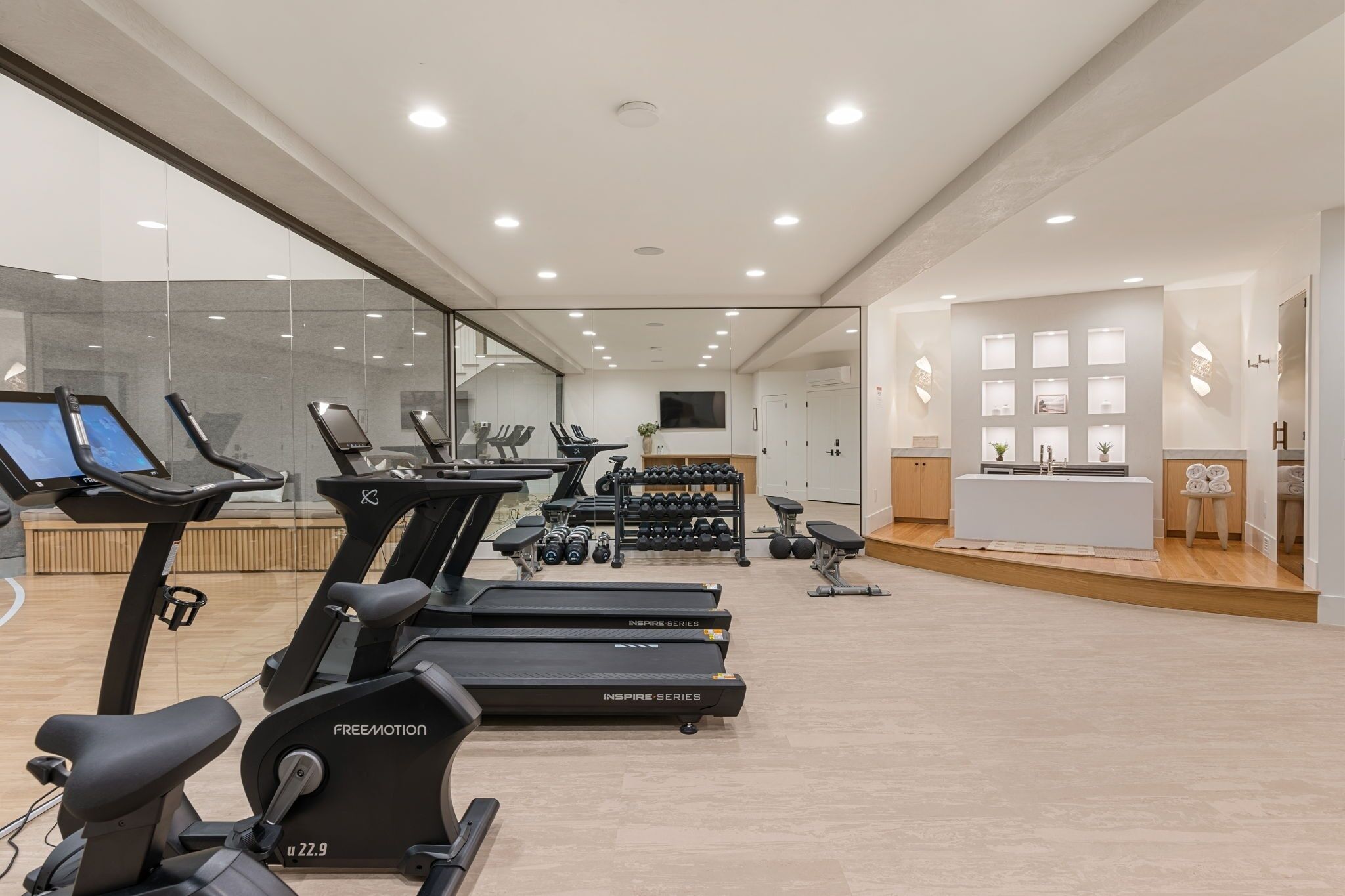 A modern gym with treadmills, exercise bikes, and free weights.