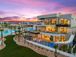 Un edificio moderno de varios pisos con piscina, mobiliario exterior y vistas del entorno.