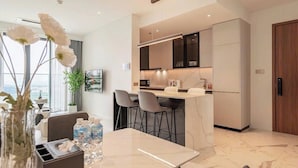 Una cocina moderna con encimera de mármol, armarios negros y una zona de bar.