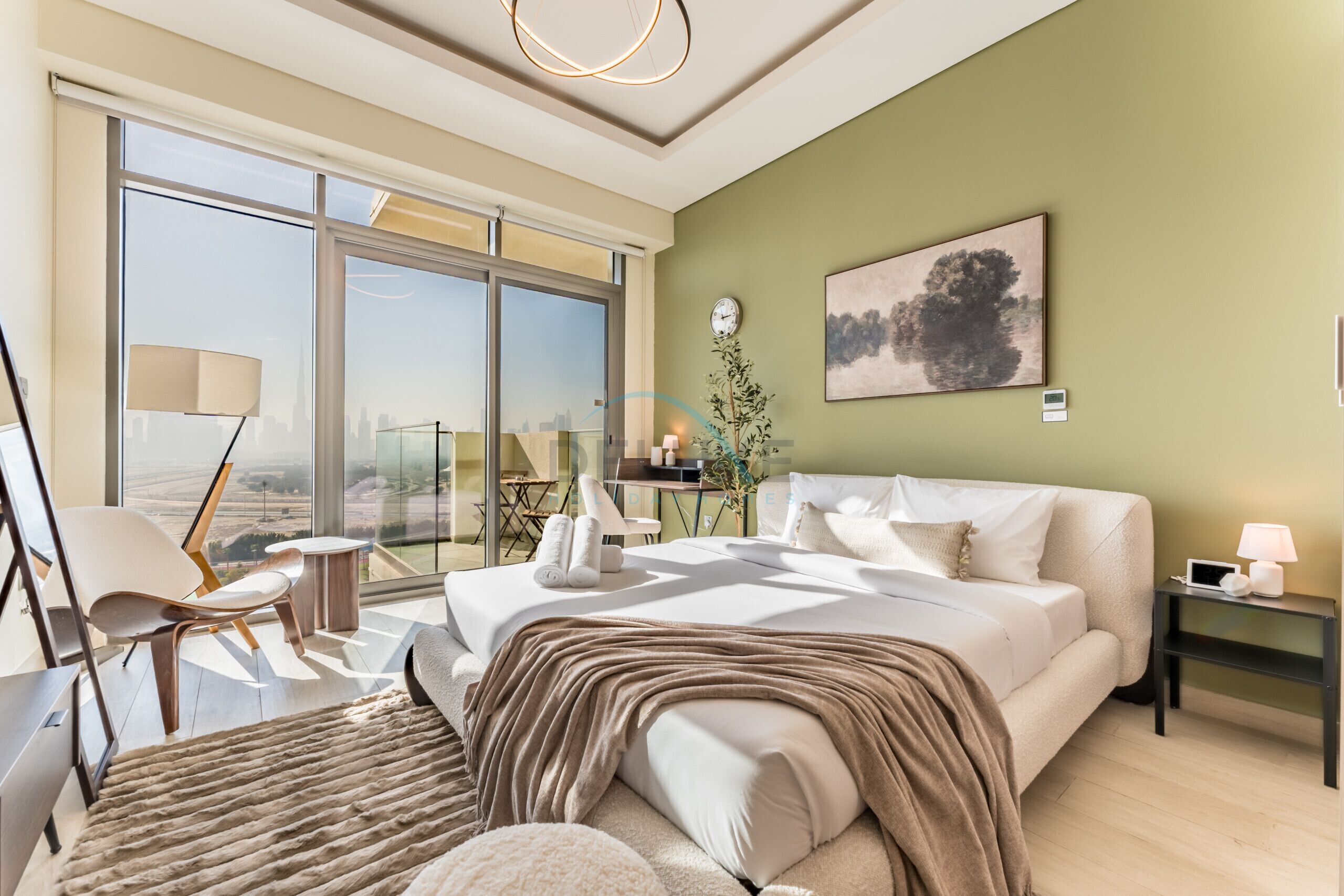 Un dormitorio moderno con una cama grande, vistas a la ciudad, un escritorio y una silla.