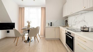 Una cocina moderna con encimera de mármol, horno empotrado y comedor con mesa y sillas.