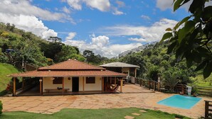 A house with a tiled roof, a swimming pool, and a patio area. - S tio Toca dos Gatos com Piscina e Churrasqueira (Sabinópolis)