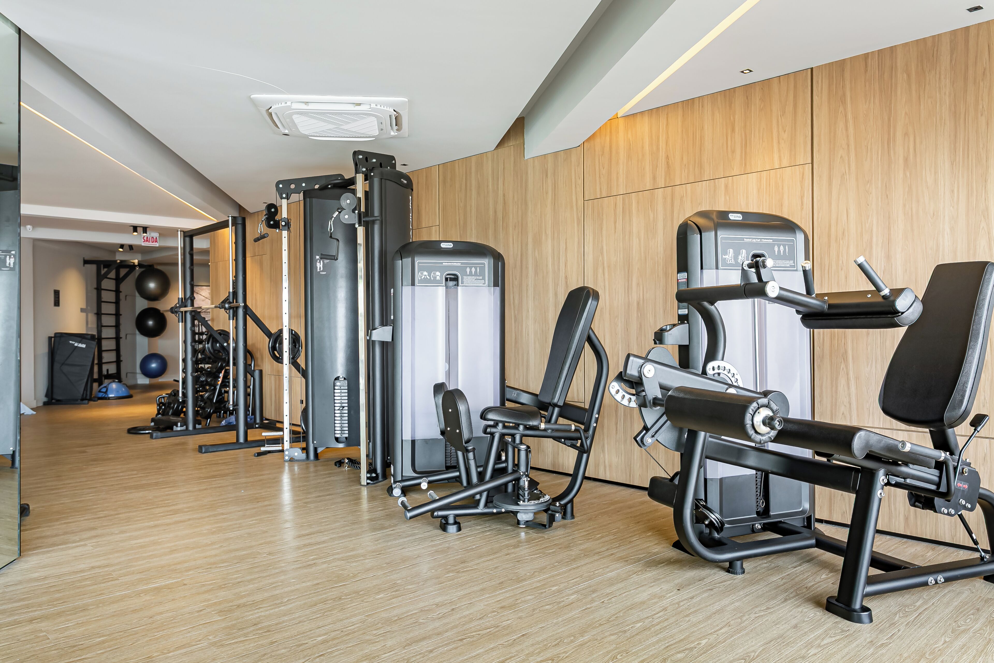 Una palestra moderna con diverse attrezzature per esercizi, tra cui una panca per squat, una panca per distensioni e pesi liberi.