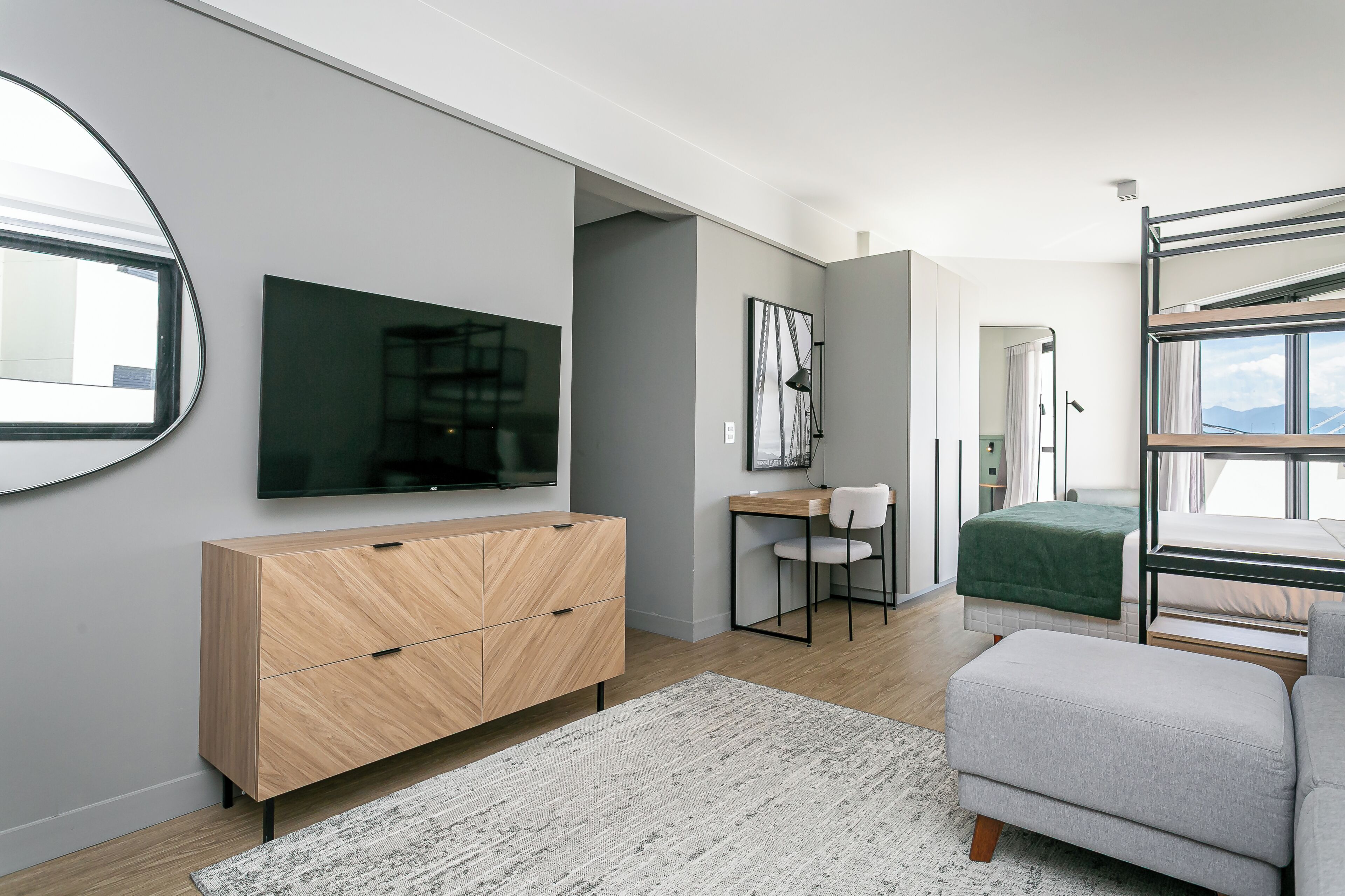 Una camera moderna con un letto a castello, una scrivania, una sedia, una televisione e un armadio.