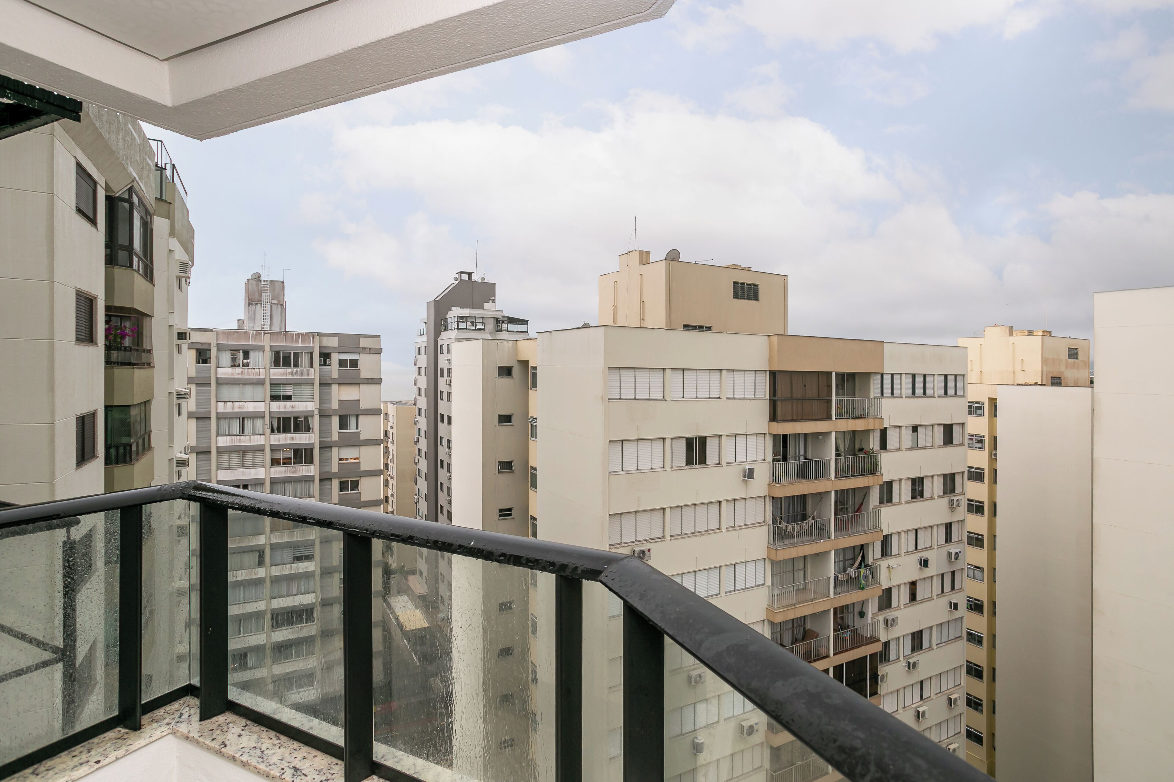 Um edifício residencial alto, com várias sacadas e uma vista ampla da área urbana ao redor.