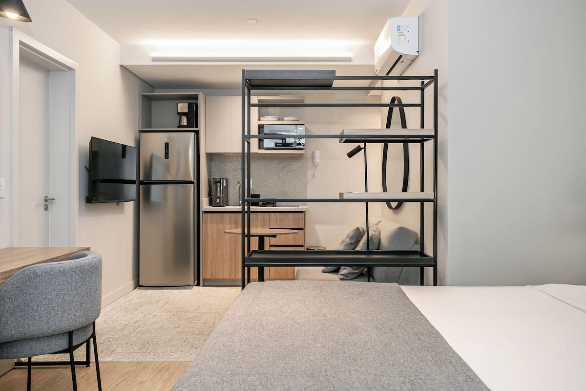 A compact kitchenette with a built-in refrigerator, microwave, and coffee maker.