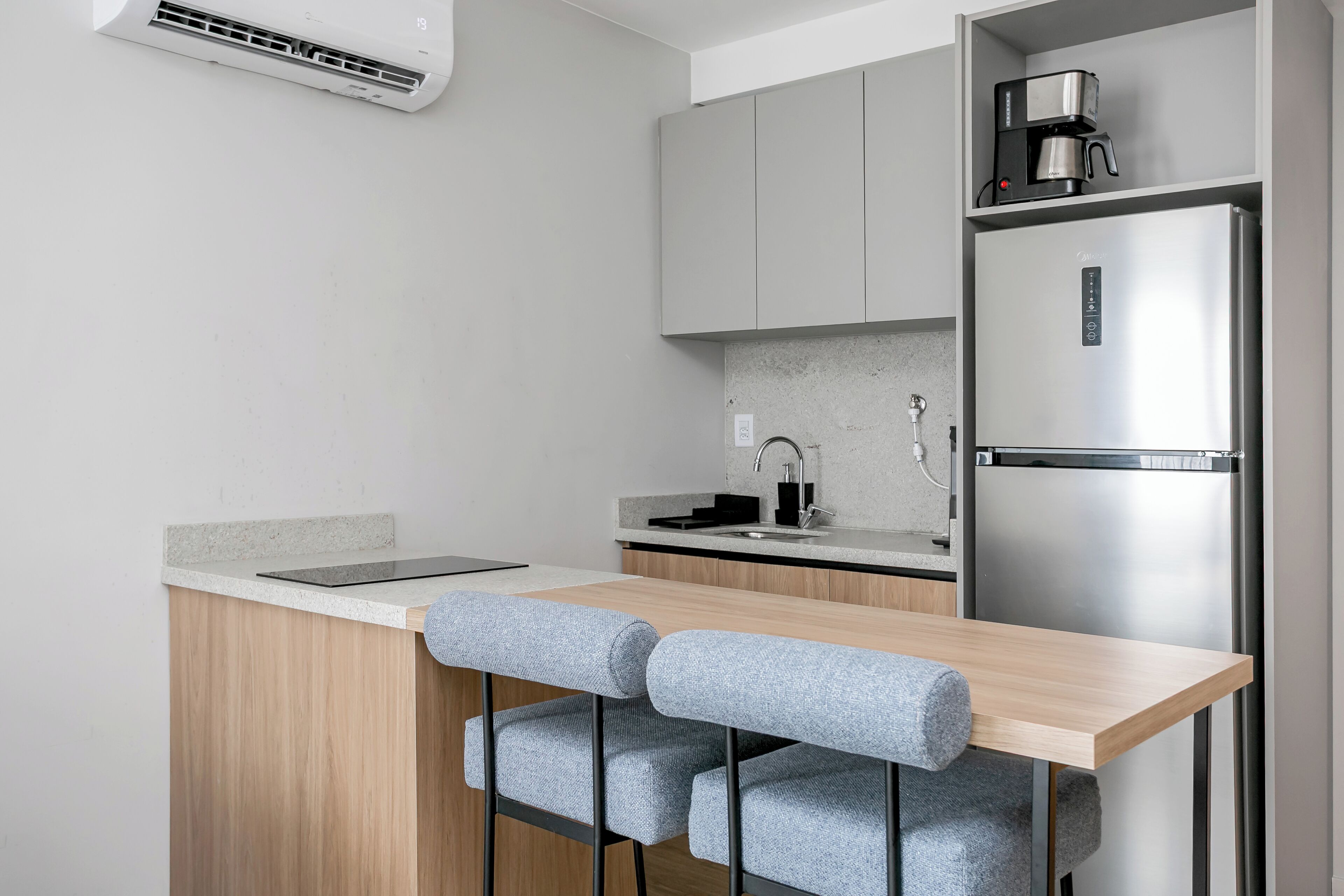 Eine moderne Küche mit einer Holz Arbeitsplatte, einem Edelstahl-Kühlschrank und einer Kaffeemaschine.