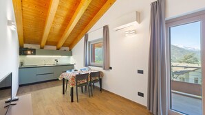 A dining area with a table, chairs, and a view through a window. - Suly Apartments 3 – Modern Accessible Stay with Mountain Views in Saint-Vincent (Cillian)