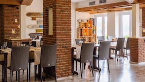 Un restaurante con paredes de ladrillo, vigas de madera y sillas de mimbre.