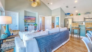 Amplia sala de estar con sofá, mesa de comedor y cocina equipada con electrodomésticos modernos.