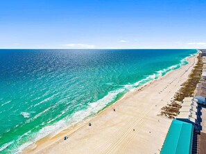 A beach with a clear view of the ocean and a resort area with buildings along the shore. - Beach & Lake | Private Pool | Game Room | Near 30A (Panama City Beach)