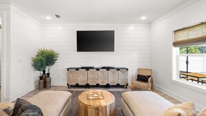 A living room with a flat-screen TV mounted on the wall, a sofa set, a coffee table, and a side table. - Beach & Lake | Private Pool | Game Room | Near 30A (Panama City Beach)
