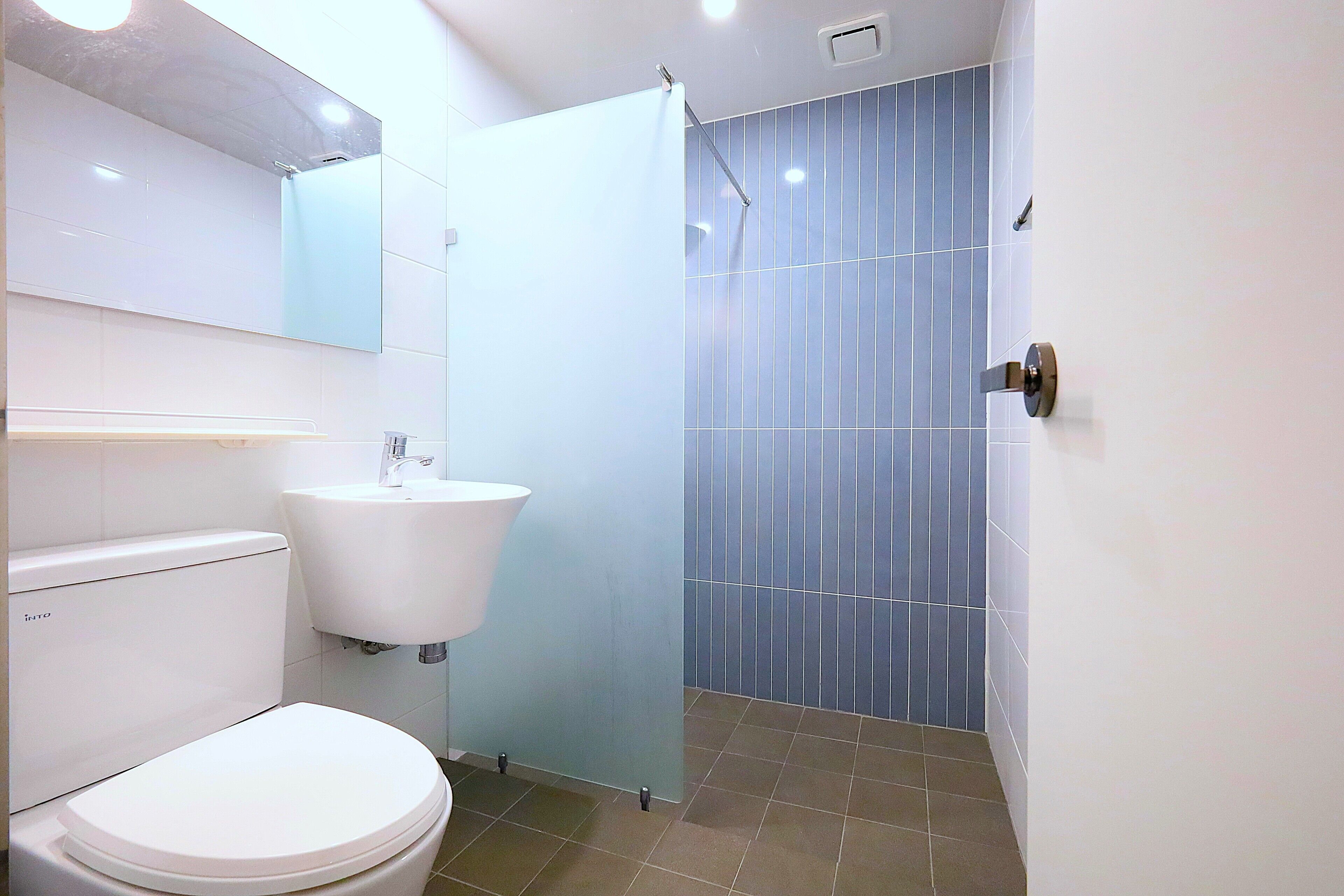 A bathroom with a toilet, sink, and shower.