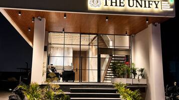 Un edificio moderno con un cartel que dice 'THE UNIFY ROOFTOP BANQUET RESTAURANT'.