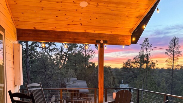 A deck with a wood-burning stove, chairs, and a view of the forest. - Luxe Forest A-Frame Escape w/ Deck & Fire-Pit (Heber-Overgaard)