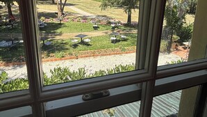 Vista a través de una ventana con un pestillo en el lado izquierdo para mantenerla abierta.