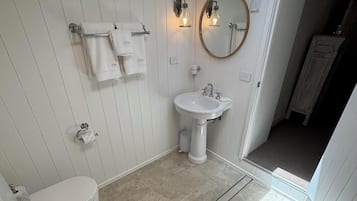 Een douche, handdoeken, zeep, toiletpapier
