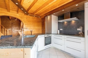 A modern kitchen with wooden walls, white cabinets, and granite countertops. - Superb vacation chalet with pool & jacuzzi - La Bresse (La Bresse)