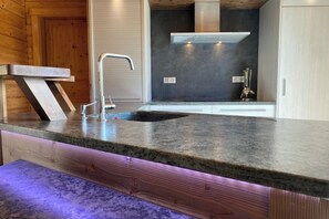 A modern kitchen with a granite countertop, stainless steel faucet, and a built-in range hood. - Superb vacation chalet with pool & jacuzzi - La Bresse (La Bresse)