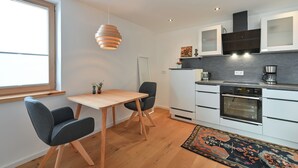 A modern kitchen with white cabinets, a built-in oven, and a coffee maker. - New & high-quality furnished guest house in a quiet location - Burgberg im Allgäu (Burgberg im Allgäu)