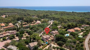 An aerial view of a residential area with houses, a swimming pool, and a red location marker. - Villa Simona in Santa Margherita di Pula: Relax, Privacy and Nature (Santa Margherita di Pula)