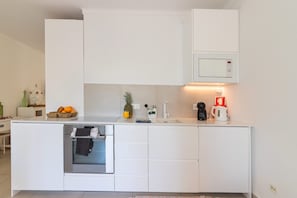 Eine moderne Küche mit Einbauofen, Mikrowelle und Kaffeemaschine.