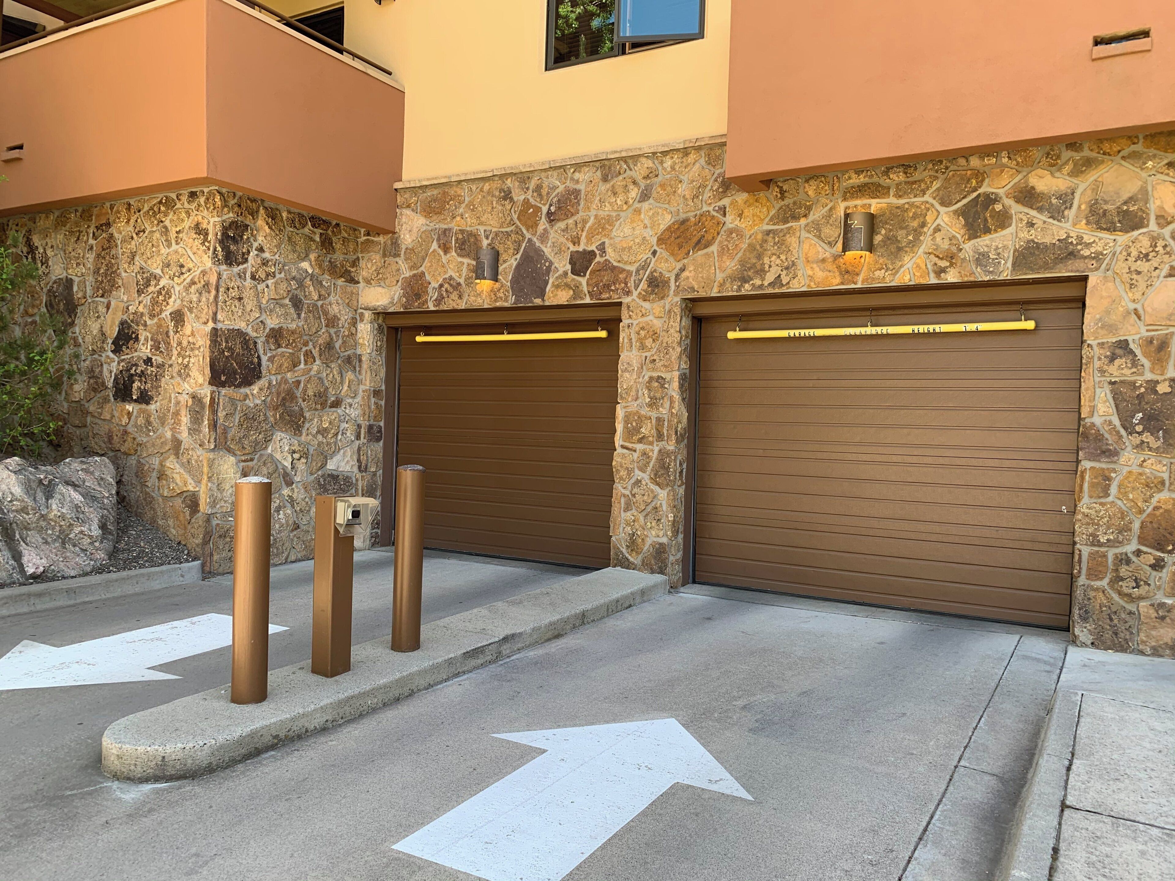 A building with stone walls and two garage doors.