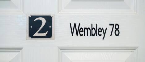 A house number '2' and the address 'Wembley 78' on a white door.
