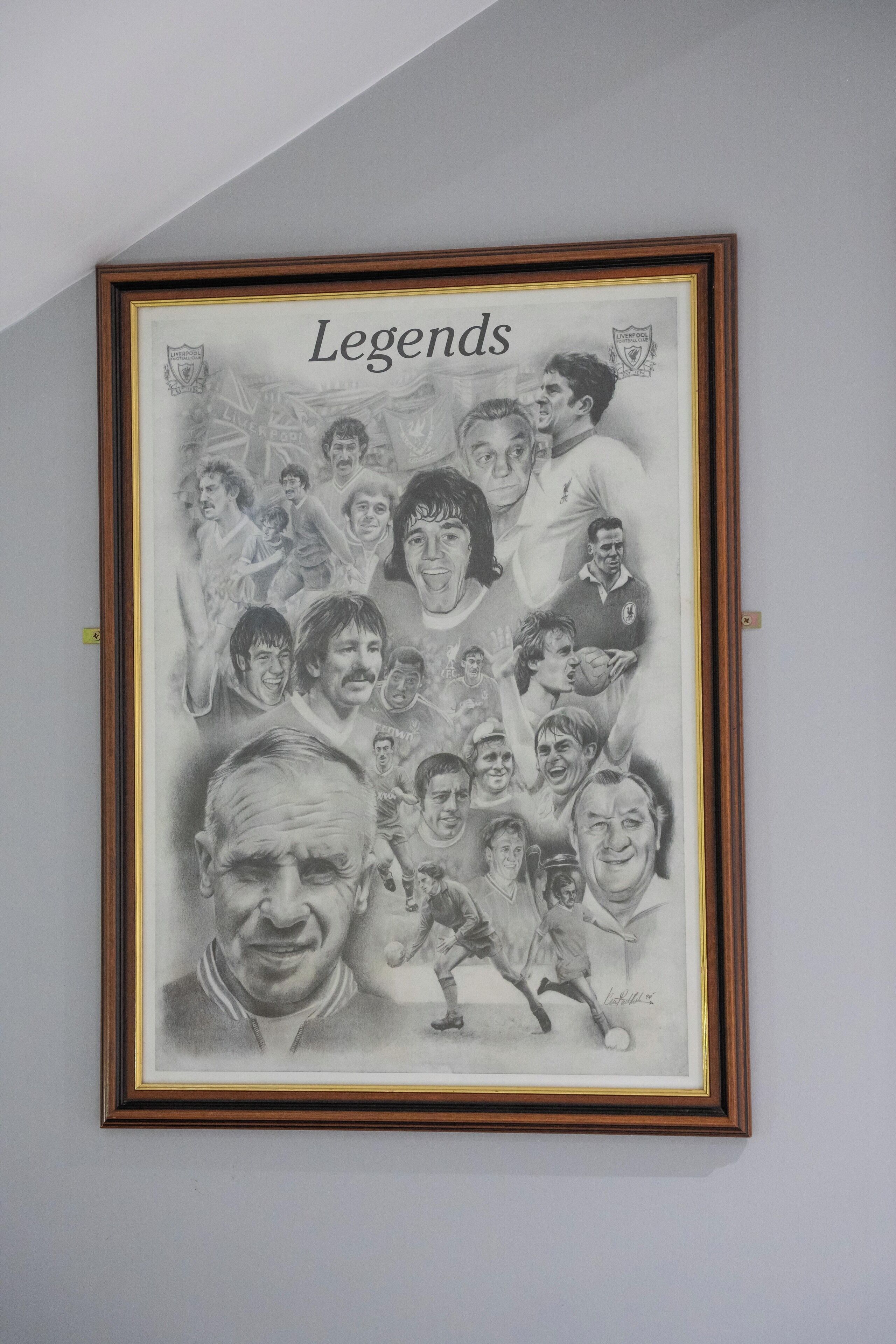 Ein gerahmtes Schwarz-Weiß-Foto von Fußballspielern mit dem Titel „Legenden“ und einer Unterschrift unten.