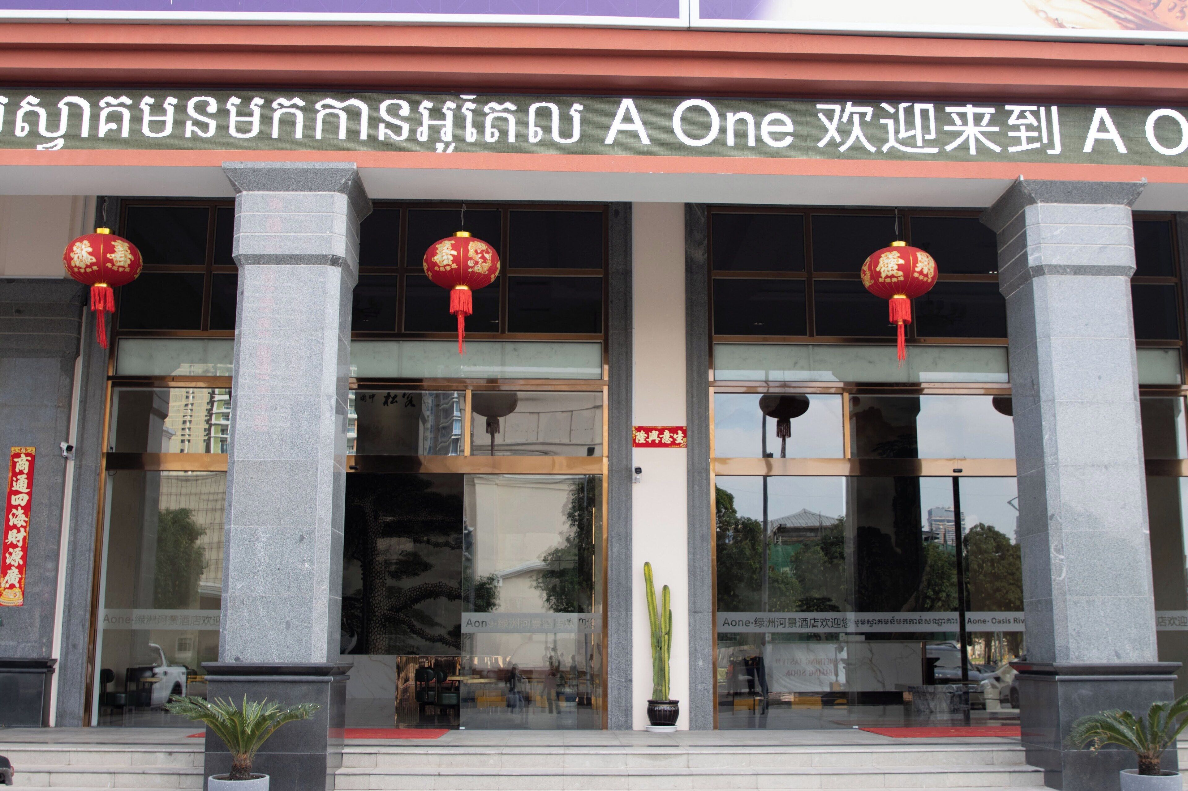 A building with large glass windows, red lanterns, and a sign in a foreign language.