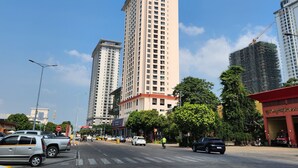 A tall building with multiple floors, surrounded by other high-rise buildings and trees. - A One Oasis River View Hotel (Phnom Penh)