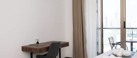 Una habitación de hotel con escritorio, silla y cama con toallas.