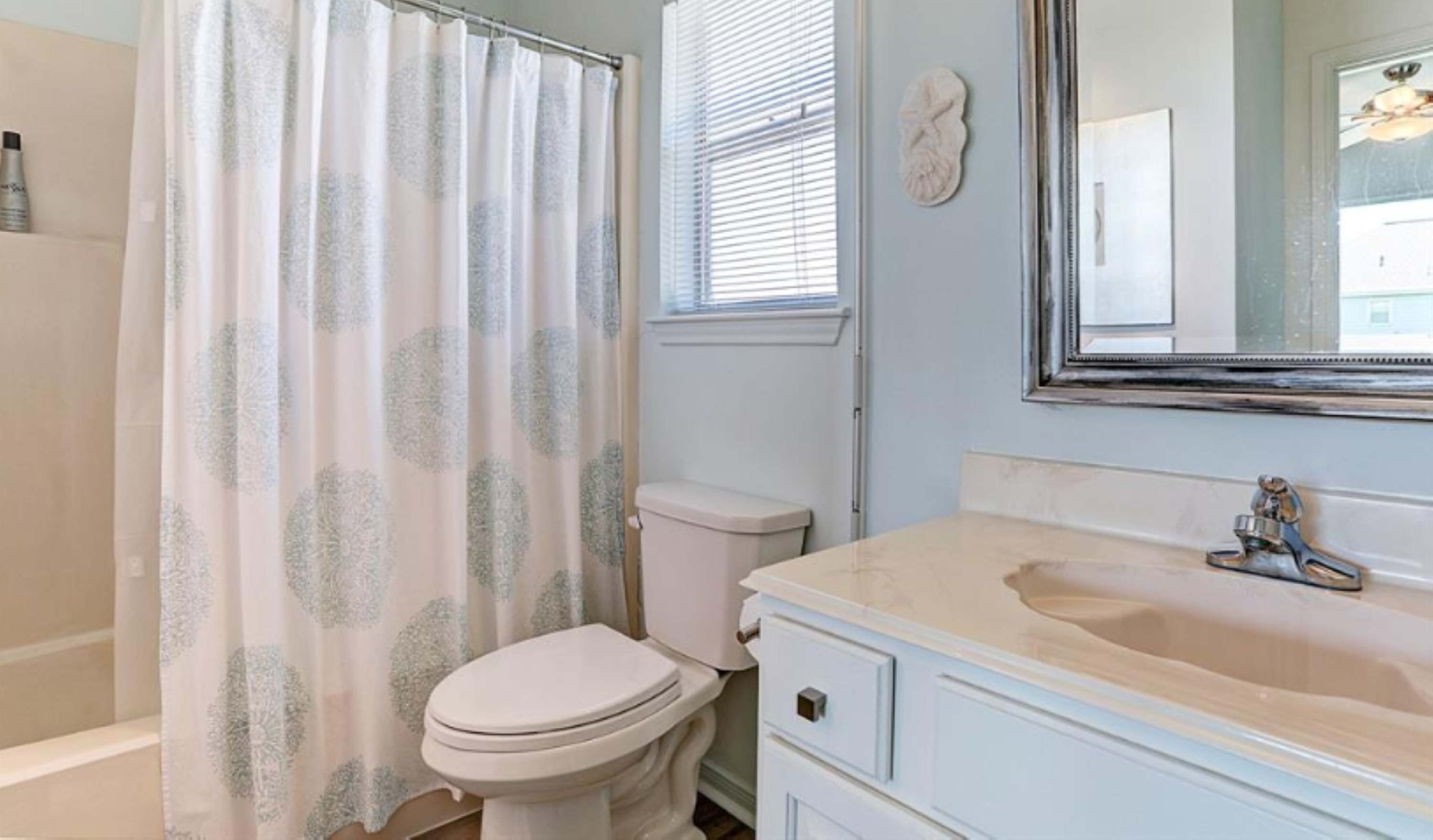 A bathroom with a toilet, a sink, and a shower curtain.