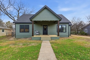A single-story house with a front porch, a visible number "15" on the door, and a clear sky. - The Bella - Modern Equestrian Home with Park Views near Weatherford Square! (Weatherford)