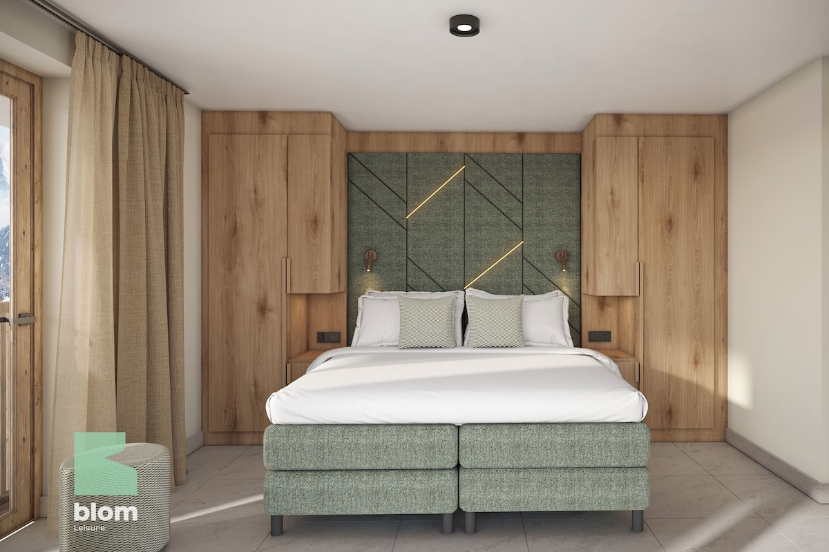 Ein modernes Schlafzimmer mit Bett, Vorhängen und Holzwandverkleidung.